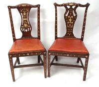 Two Chippendale style walnut dining chairs, each with pierced splat backs and both profusely