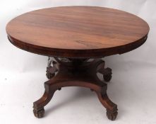 Early 19th century rosewood circular dining table raised on swept open work column, terminating in a