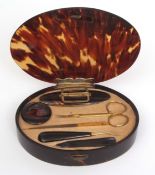 Early 20th century silver gilt and tortoiseshell dressing table manicure set of oval form, the plain