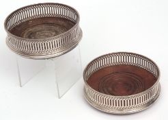 Two Elizabeth II silver mounted bottle coasters, each with pierced borders and ring turned centres