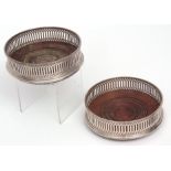 Two Elizabeth II silver mounted bottle coasters, each with pierced borders and ring turned centres