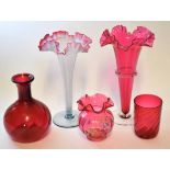 Group of cranberry wares including two large trumpet shaped vases, a further vase and a globular
