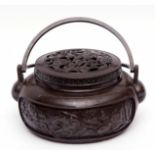 Chinese lidded bronze censer or hand warmer of circular form with double swing handles, 27cms diam