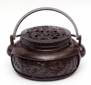 Chinese lidded bronze censer or hand warmer of circular form with double swing handles, 27cms diam