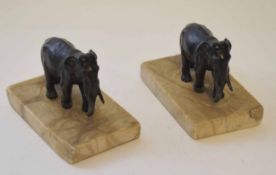 Two patinated base metal paperweights, each modelled in the form of a standing elephant each on a