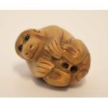 Oriental netsuke modelled as a monkey with black glass eyes