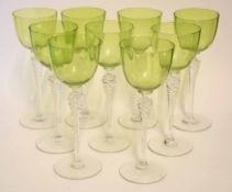 Group of nine wine glasses on tall stems, the bucket shaped bowls with a light green colour, each