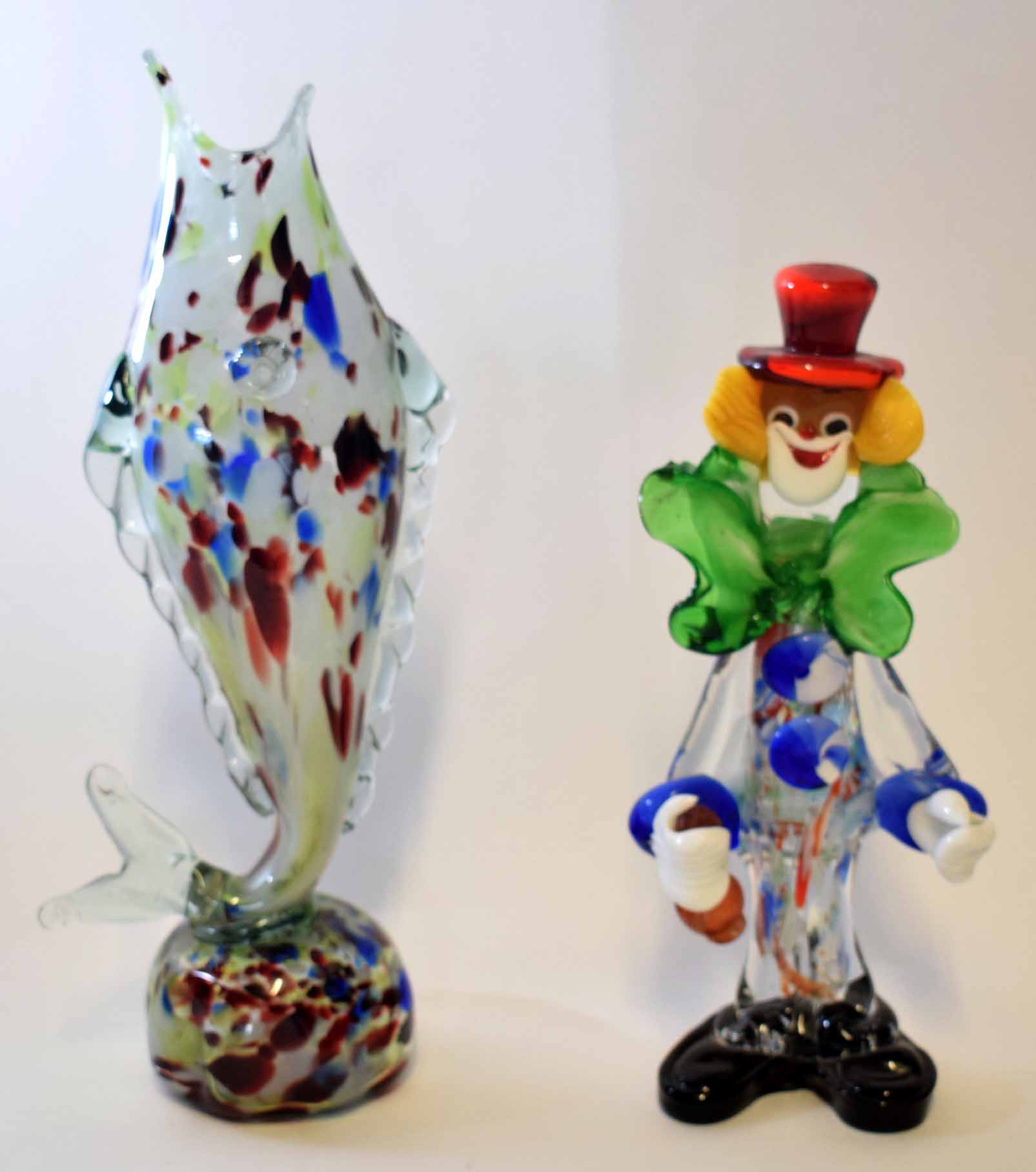 Glass clown in various colours, blue and green with red hat, together with a glass vase modelled