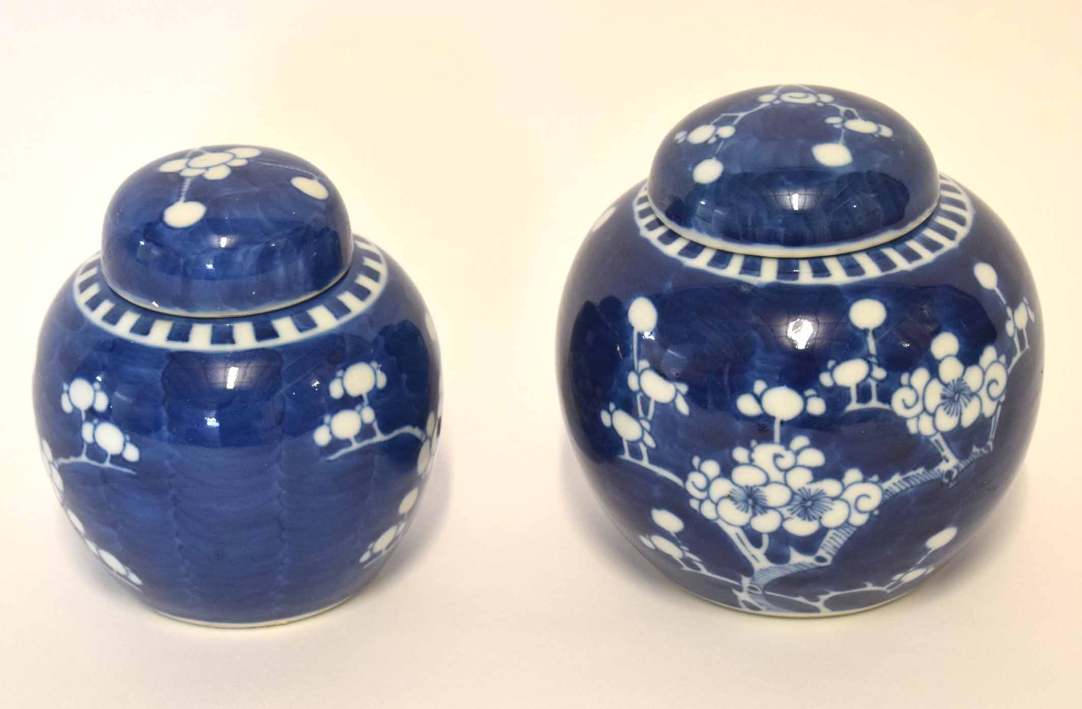 Pair of Chinese porcelain ginger jars and covers decorated with prunus on a blue ground, 12cm high