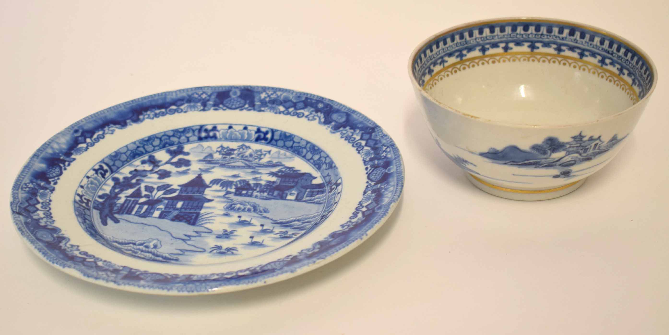 Chinese export blue and white bowl decorated with a pagoda and houses within a gilt rim, together