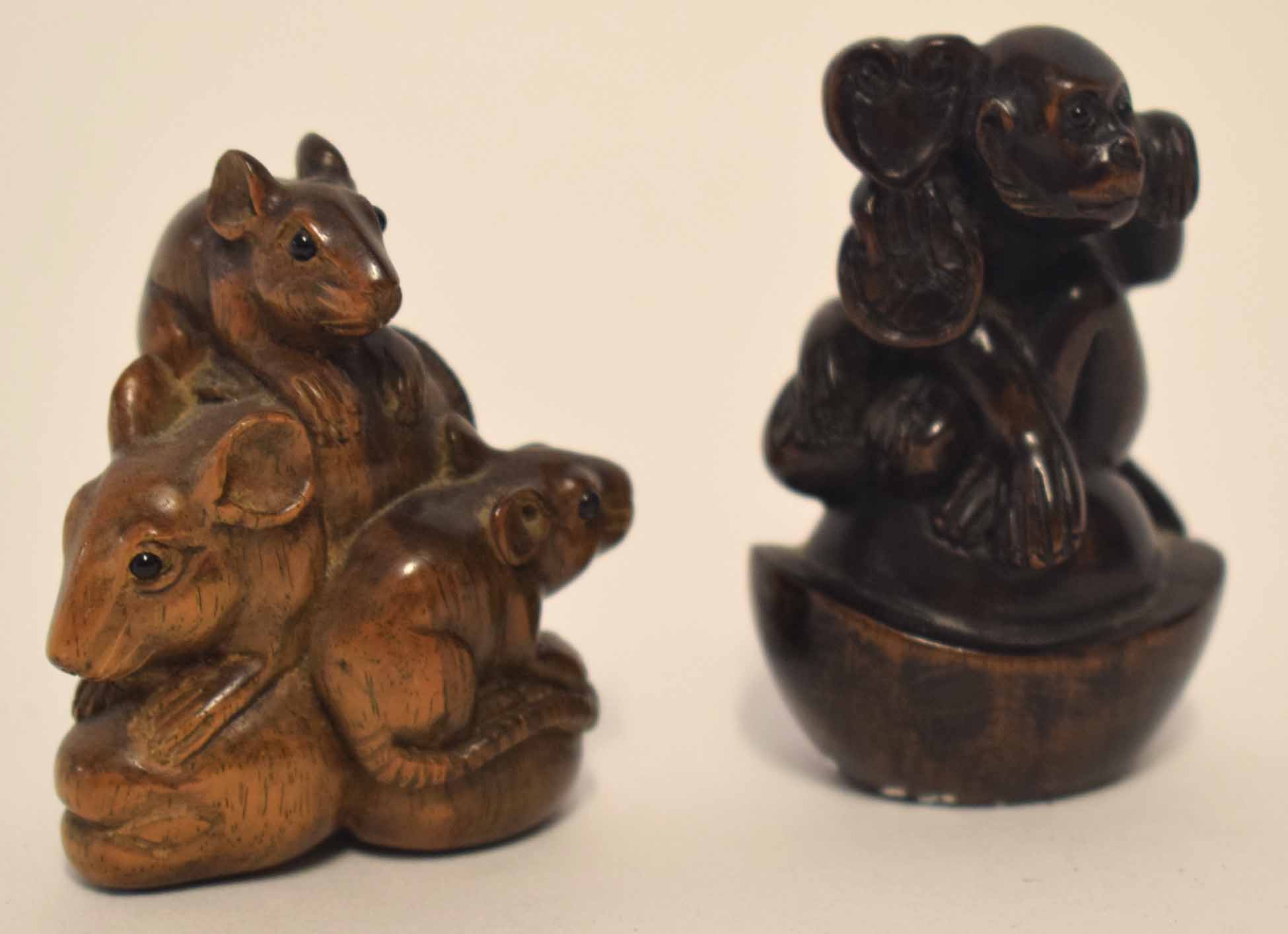 Two carved netsuke, one modelled as a monkey seated on a shell, the other as a group of three rats