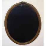 Gilt framed oval wall mirror applied with a scrolled mount, (losses throughout), 66cm high