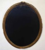 Gilt framed oval wall mirror applied with a scrolled mount, (losses throughout), 66cm high
