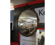 Gilt framed oval wall mirror, the frame decorated with C-scrolls, foliage etc, 97cm high