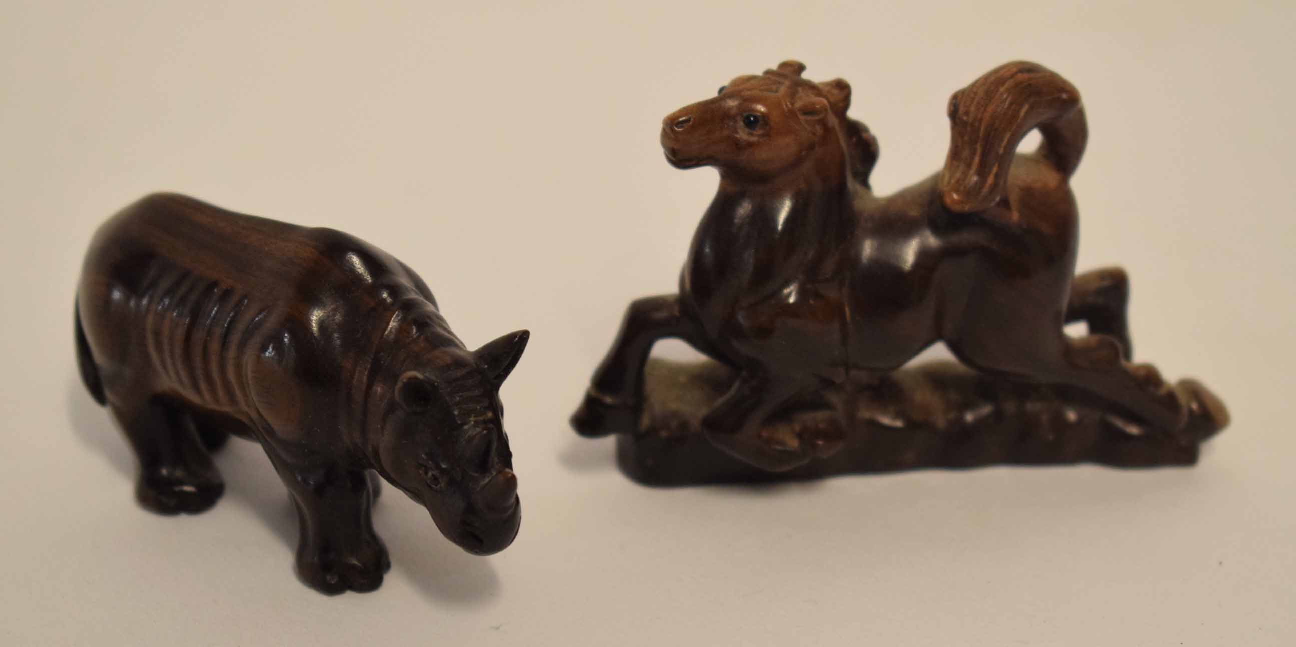 Pair of Oriental carvings, one of a rhinoceros and the other a horse