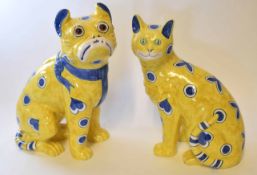 Pair of Galle style cats with blue painted designs on a yellow ground, the largest 36cm