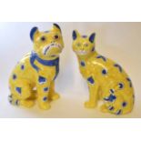 Pair of Galle style cats with blue painted designs on a yellow ground, the largest 36cm