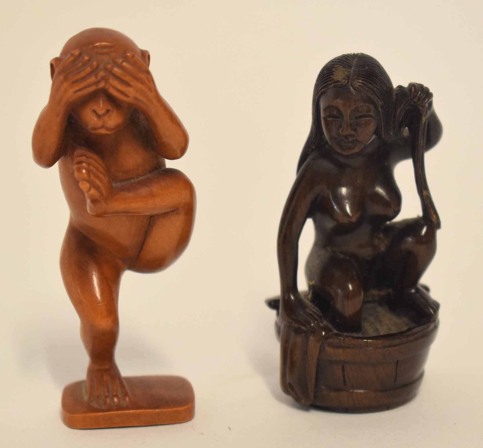 Group of two carved toggles or netsuke, one modelled in wood as a monkey standing on one leg,