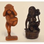 Group of two carved toggles or netsuke, one modelled in wood as a monkey standing on one leg,