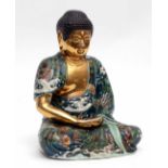 Oriental pottery model of a Buddha picked out in gilt with a green ground decoration with applied
