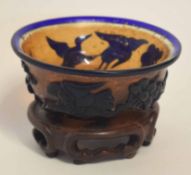 Peking glass blue ground bowl, the exterior decorated in relief with penguins and a floral design,