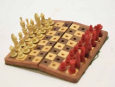 Small cased travelling chess set, the hinged rectangular box containing a folding board and carved