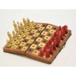Small cased travelling chess set, the hinged rectangular box containing a folding board and carved
