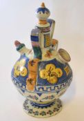 Continental pottery puzzle jug with strap handle, the body with majolica glazes with panels
