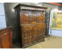 Oak court cupboard, overhanging frieze over three panelled doors, three further frieze drawers and