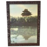 Oriental print of a temple in carved wooden frame