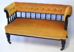 Late Victorian ebonised cottage sofa upholstered in ochre with a button back, 120cm wide