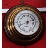 Early 20th century brass cased aneroid barometer mounted on turned oak backing to a drum shaped case