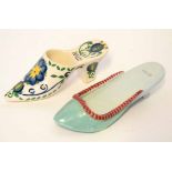 Two pottery shoes, one inscribed "Bally" and the other likewise with floral sprays, 18cm long (2)