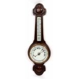 Early 20th century oak cased aneroid wheel barometer, the carved case set with a twin-scale