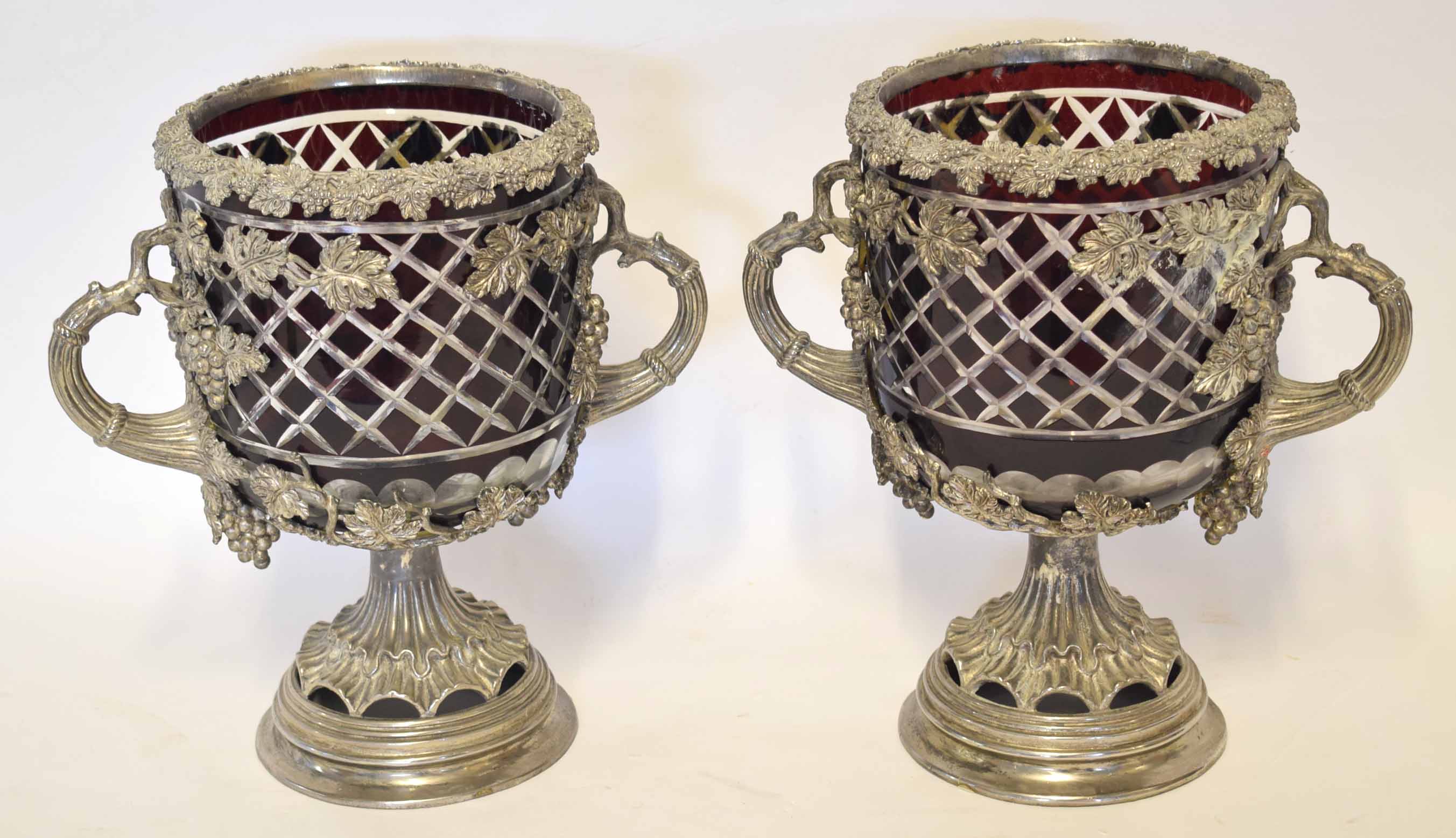Pair of wine coolers, the cranberry style body with an overlaid silver metal decoration of grapes