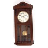 Mid-20th century stained beech wall clock, the shaped pediment to a panelled and glazed door with