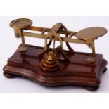 Late 19th century walnut and brass postal scale, of typical form with serpentine base on bun feet
