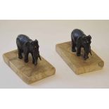 Two patinated bronzed spelter paperweights, each modelled in the form of a standing elephant each on