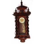 Early 20th century walnut cased Vienna type wall clock, the overhanging cornice surmounted by an