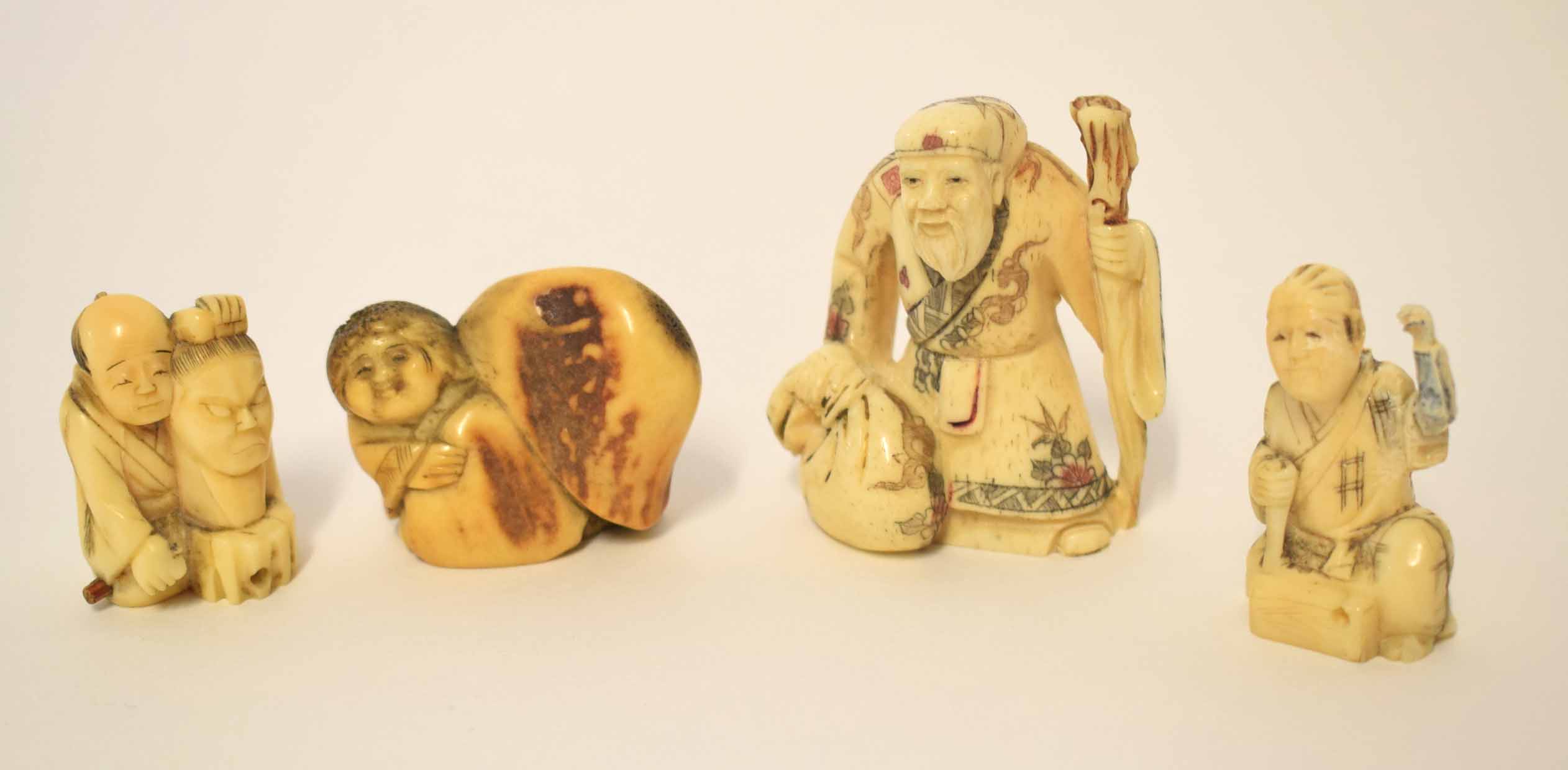 Group of Oriental carvings and netsuke comprising a carving of an immortal with staff plus three