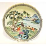 Chinese porcelain charger with polychrome decoration of horses in a landscape setting in primarily