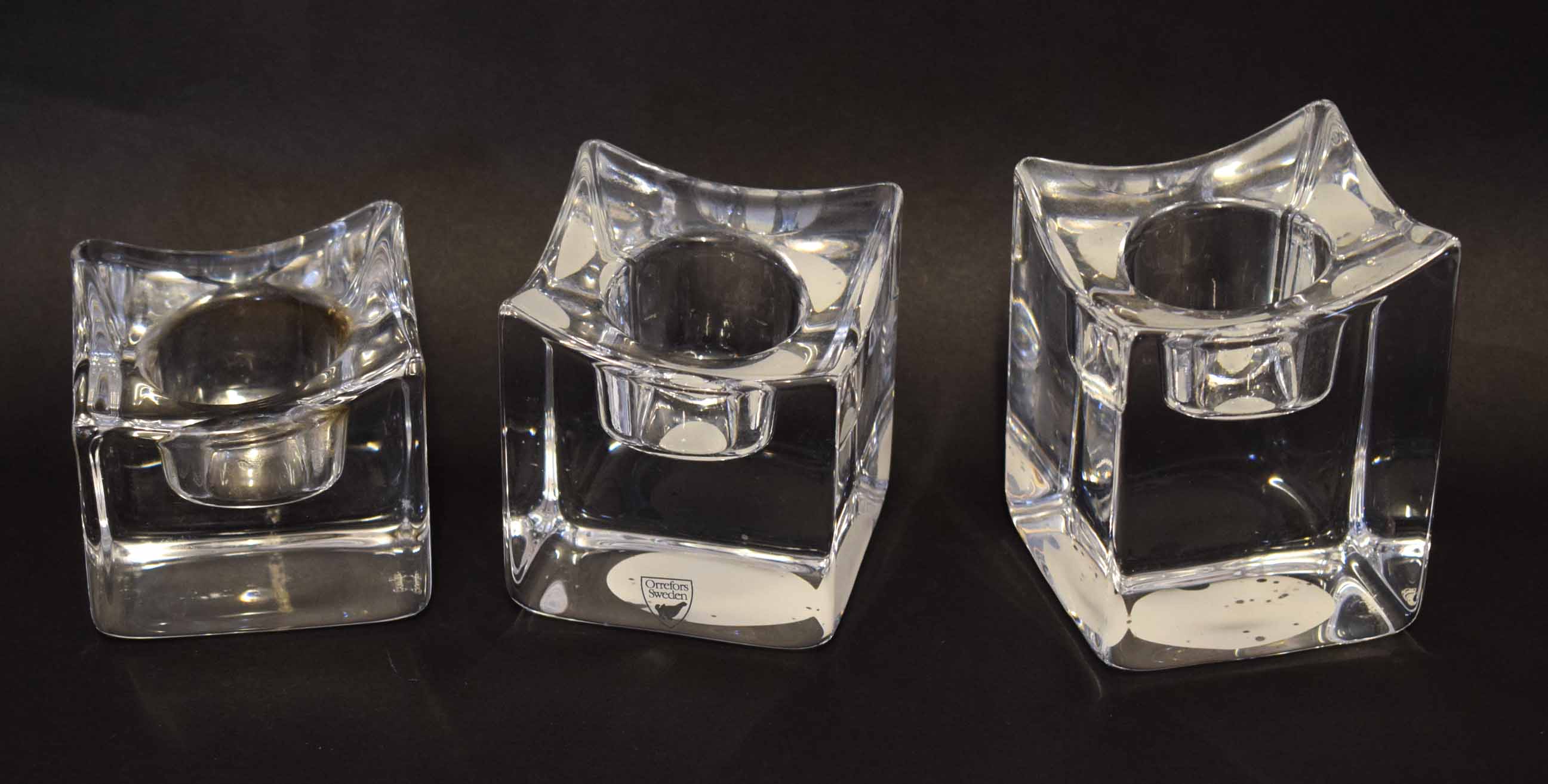 Boxed set of three Orrefors glass candle holders, 10cm high, the holders with etched Orrefors