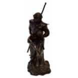 Bronze patinated cast metal study of a theatrical monkey, a spear in his right hand and a fruit in