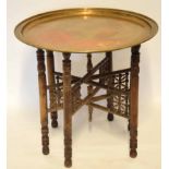 Brass topped Benares table with folding support, circa late 19th century, 58cm diam
