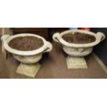 Large pair of composite garden urns on square plinths, decorated in classical style with swags and