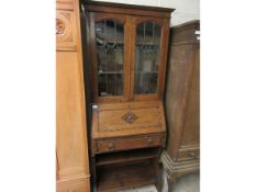 EARLY 20TH CENTURY OAK FRAMED BUREAU BOOKCASE WITH TWO LEADED AND GLAZED DOORS THE DROP FRONT WITH