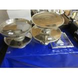 FOUR CIRCULAR CHROMIUM CAKE STANDS TOGETHER WITH A GLASS FRAMED CAKE STAND (5)