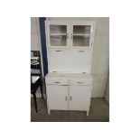 WHITE PAINTED KITCHEN CUPBOARD WITH DROP FRONT WITH ENAMEL TOP FITTED WITH TWO GLAZED DOORS AND