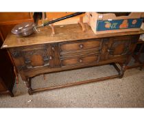 EARLY 20TH CENTURY OAK FRAMED SIDEBOARD WITH TWO DRAWERS FLANKED EITHER SIDE BY CARVED PANELLED