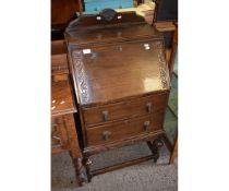 MID-20TH CENTURY OAK FRAMED DROP FRONTED BUREAU WITH CARVED DETAIL WITH TWO DRAWERS ON A STAND